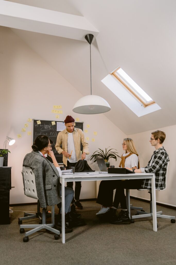 A group of young professionals discussing ideas in a modern office space.